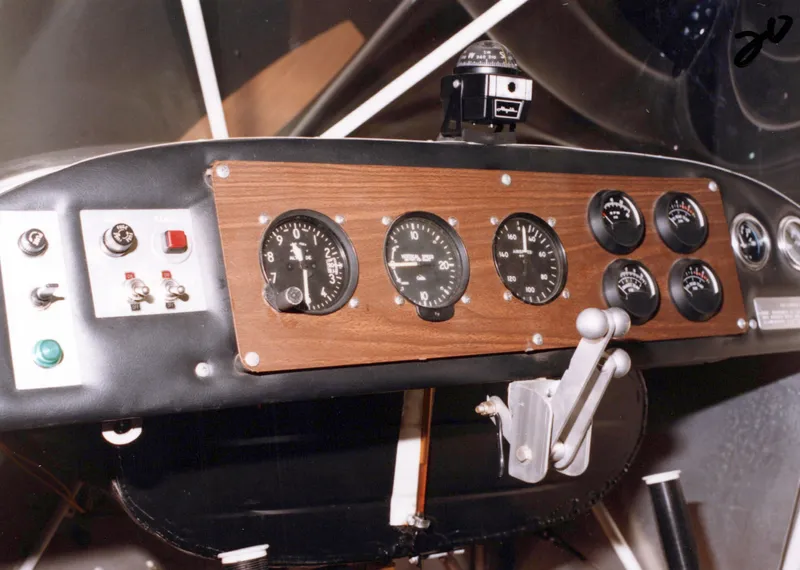 The wood-faced instrument panel of a Carlson Sparrow II with round gauges, switches and the control stick