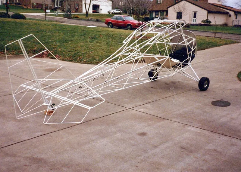 A bare welded steel-tube fuselage frame of a Carlson Sparrow on a driveway